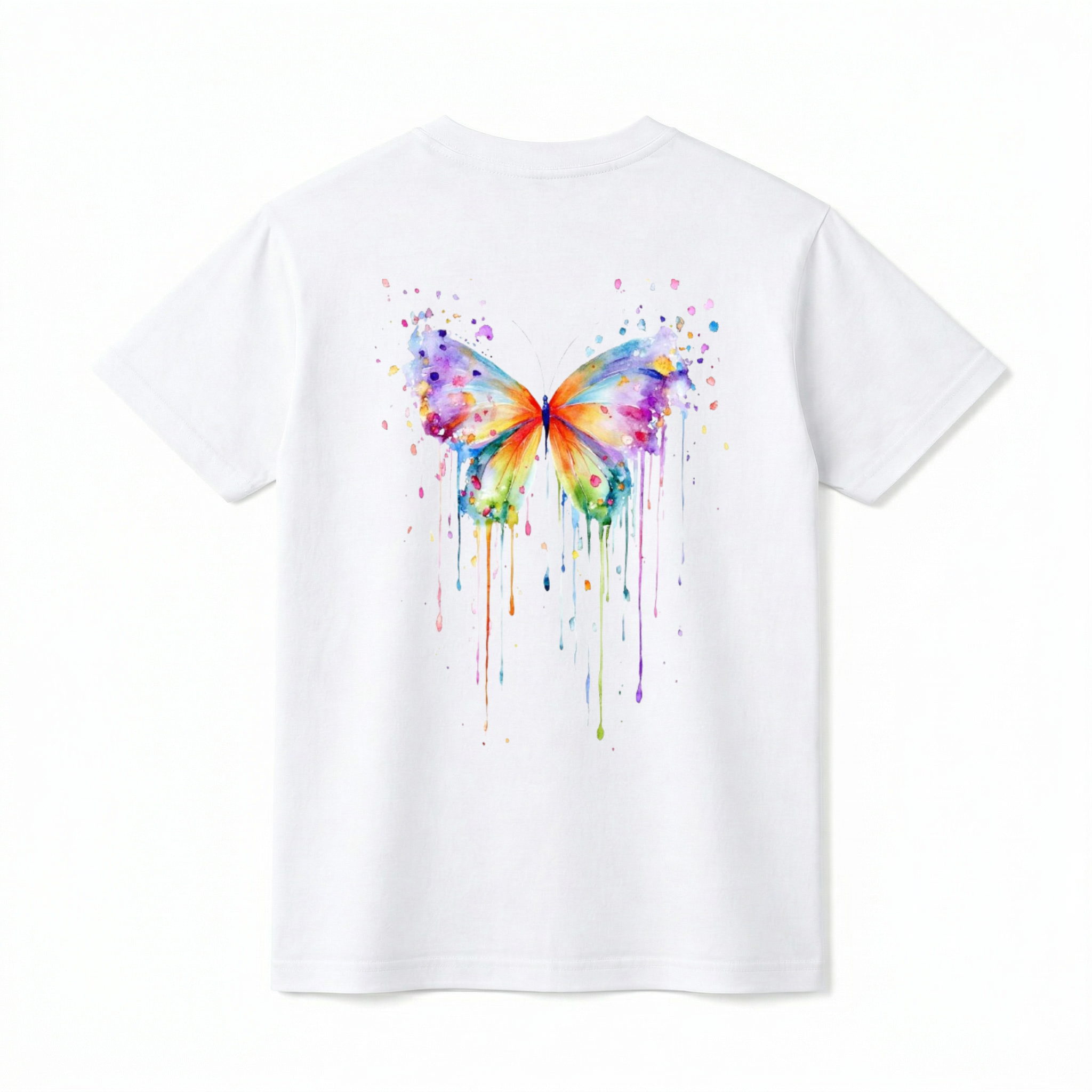 A flat lay showing the back of a short-sleeve t-shirt. The center features a large, vibrant watercolor painting of a butterfly. The butterfly's wings are filled with a rainbow of blended colors, including purple, blue, orange, yellow, and green. The design incorporates artistic paint splatters around the top and long, colorful watercolor drips running down from the bottom edges of the wings.