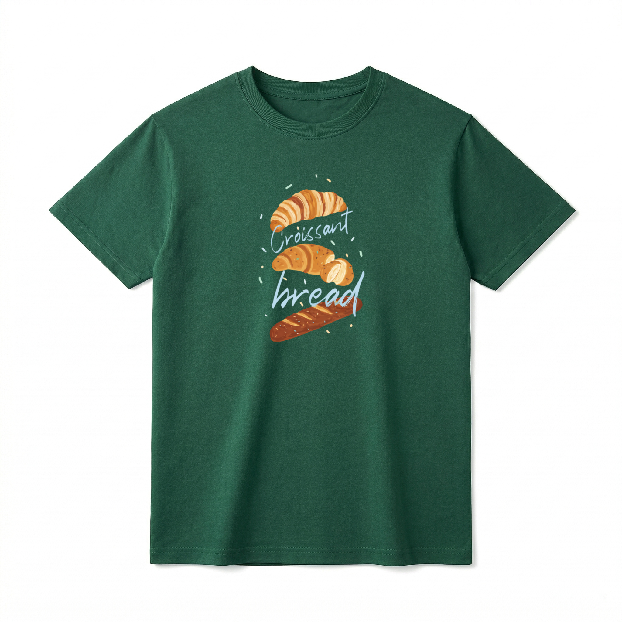 A flat lay of a short-sleeve t-shirt. The center chest features a hand-drawn graphic of vertically stacked baked goods: a golden croissant at the top, a sliced pastry in the middle, and a seeded baguette at the bottom. Light blue script text reading "Croissant" and "bread" is woven playfully across and between the pastries, surrounded by tiny, colorful confetti accents.