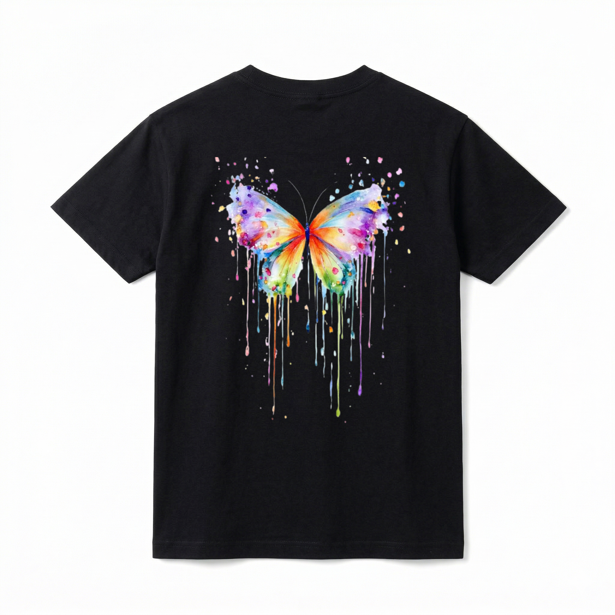 A flat lay showing the back of a short-sleeve t-shirt. The center features a large, vibrant watercolor painting of a butterfly. The butterfly's wings are filled with a rainbow of blended colors, including purple, blue, orange, yellow, and green. The design incorporates artistic paint splatters around the top and long, colorful watercolor drips running down from the bottom edges of the wings.