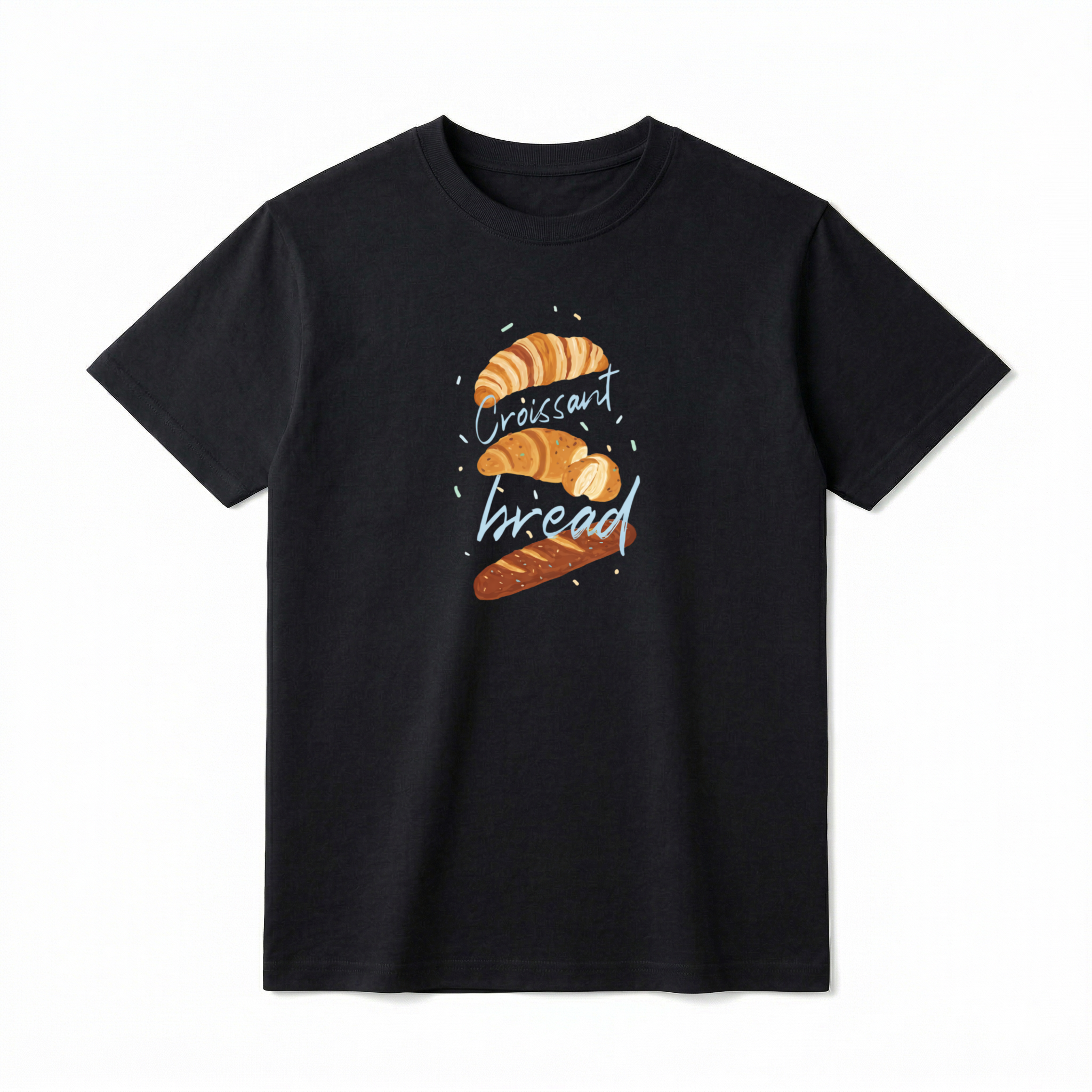 A flat lay of a short-sleeve t-shirt. The center chest features a hand-drawn graphic of vertically stacked baked goods: a golden croissant at the top, a sliced pastry in the middle, and a seeded baguette at the bottom. Light blue script text reading "Croissant" and "bread" is woven playfully across and between the pastries, surrounded by tiny, colorful confetti accents.