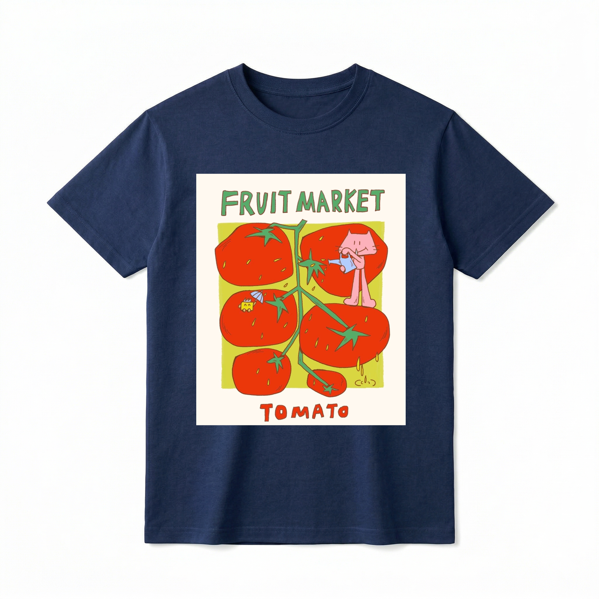 A flat lay of a short-sleeve t-shirt. The center features a colorful graphic with the text "FRUIT MARKET" at the top in green, hand-drawn letters. Below it is a light green square containing illustrations of a vine with five large, bright red tomatoes. A cute pink cartoon cat stands on one of the tomatoes, pouring water from a small blue watering can. Another tomato features a tiny yellow creature holding a blue umbrella. The word "TOMATO" is printed at the bottom in bold red text.