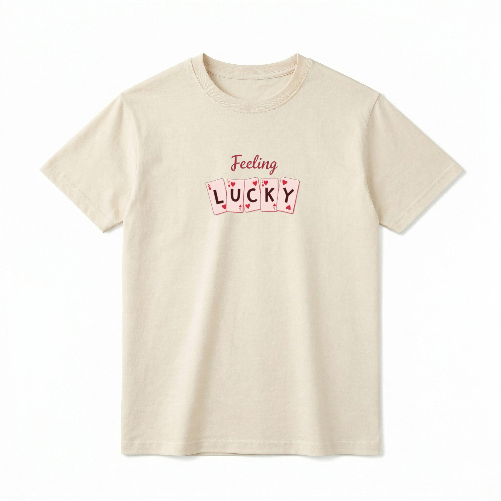 A flat lay of a short-sleeve t-shirt. On the front chest, script text reads "Feeling" above a row of five slightly overlapping playing cards. One letter is centered on each card, spelling out the word "LUCKY".