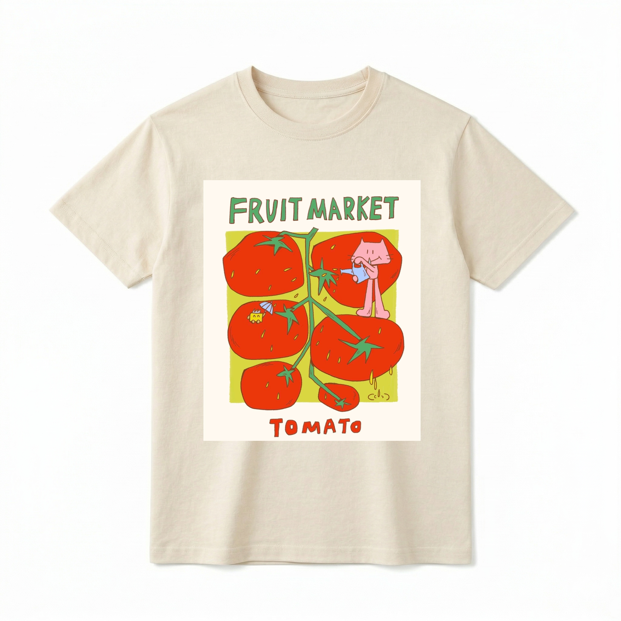 A flat lay of a short-sleeve t-shirt. The center features a colorful graphic with the text "FRUIT MARKET" at the top in green, hand-drawn letters. Below it is a light green square containing illustrations of a vine with five large, bright red tomatoes. A cute pink cartoon cat stands on one of the tomatoes, pouring water from a small blue watering can. Another tomato features a tiny yellow creature holding a blue umbrella. The word "TOMATO" is printed at the bottom in bold red text.
