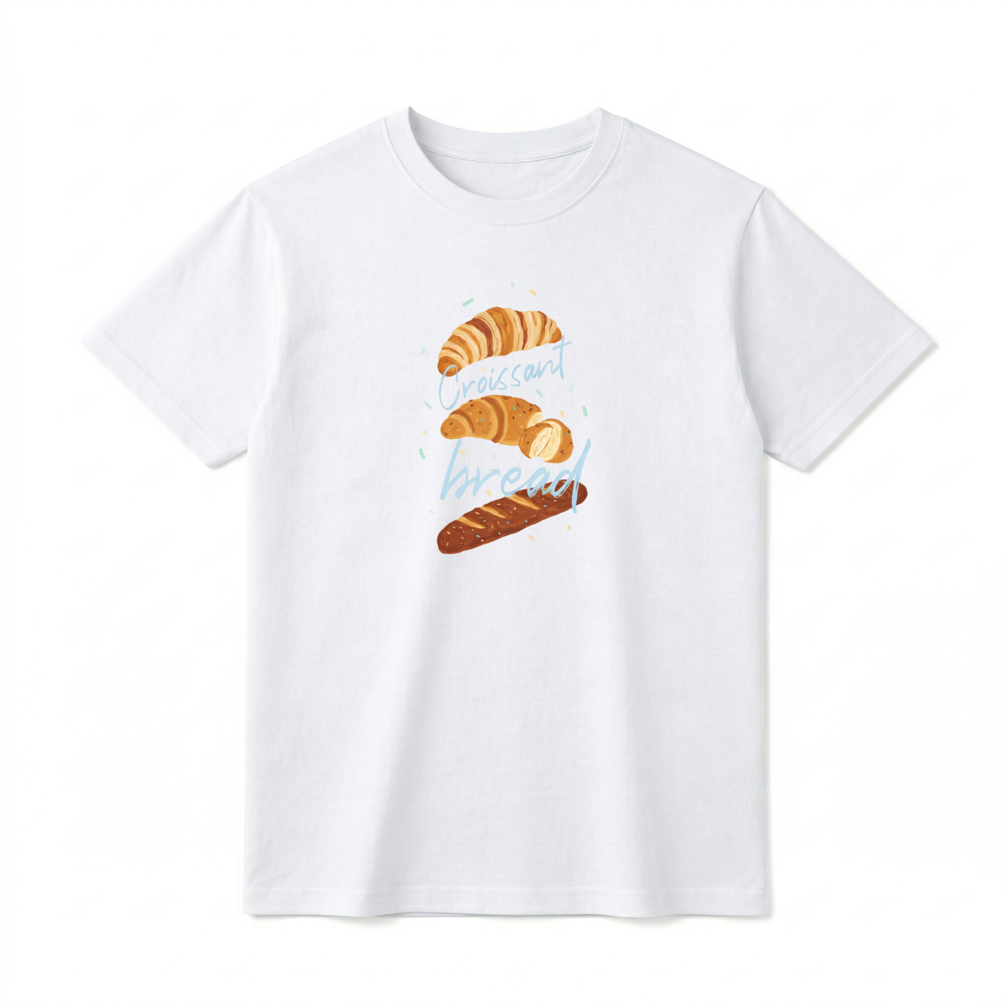 A flat lay of a short-sleeve t-shirt. The center chest features a hand-drawn graphic of vertically stacked baked goods: a golden croissant at the top, a sliced pastry in the middle, and a seeded baguette at the bottom. Light blue script text reading "Croissant" and "bread" is woven playfully across and between the pastries, surrounded by tiny, colorful confetti accents.